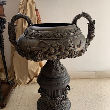 Urna de bronce vintage con detalles de flores y volutas sobre pedestal - 2/2